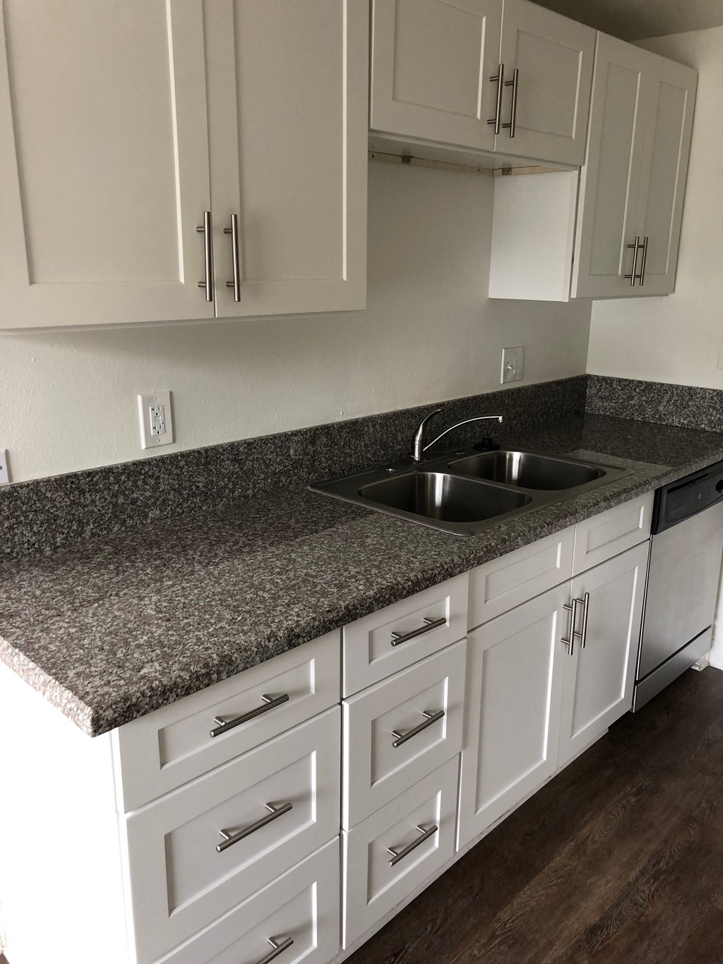 a kitchen with white cabinets and granite counter top and a sink