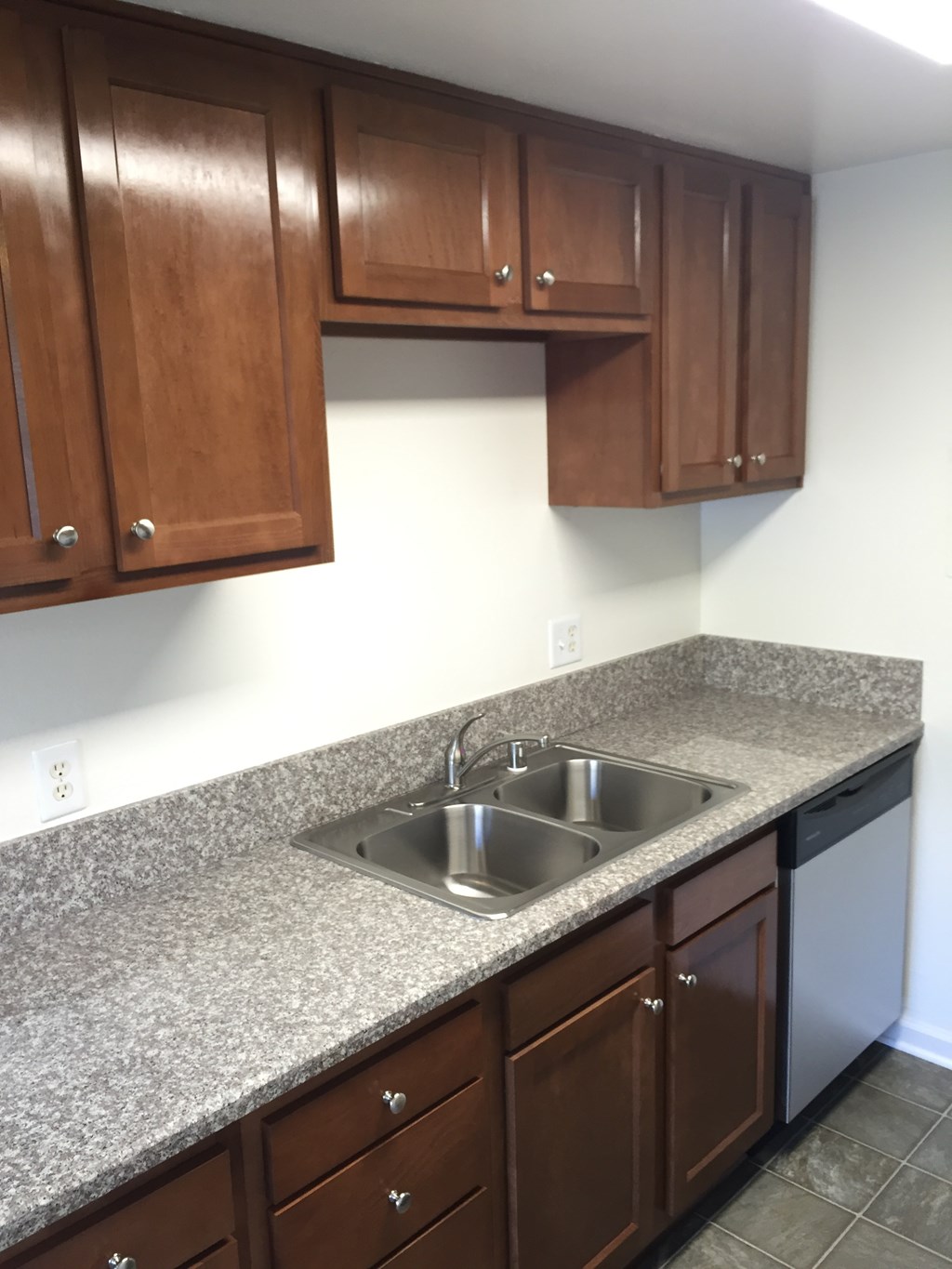 a kitchen with granite counter tops and wooden cabinets