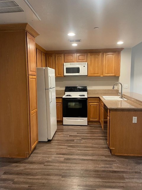 A kitchen with wooden cabinets and a white refrigerator.
