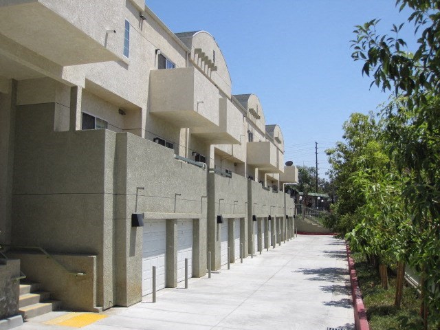 a building with a sidewalk and trees in front of it