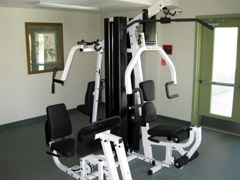 A gym with a weight machine and a chair.