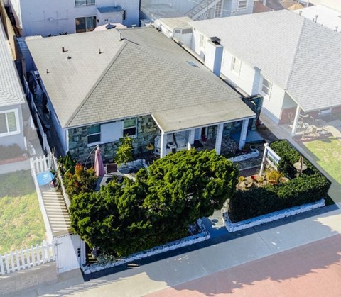 an aerial view of a white house with a roof and a porch