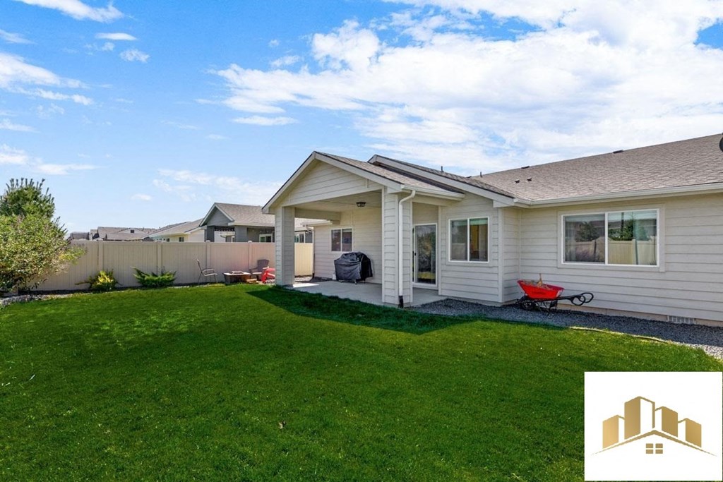 a white house with a lawn and a blue sky