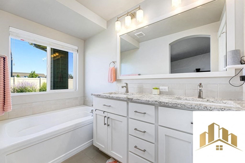 a white bathroom with a tub and a sink