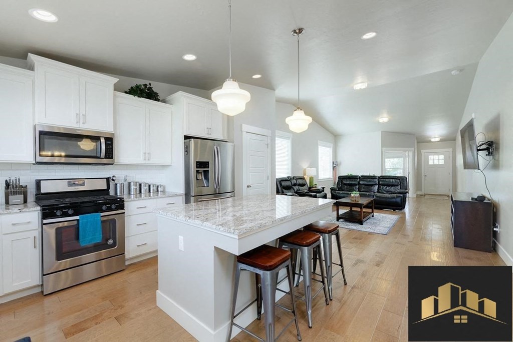 an open kitchen and living room with a marble counter top