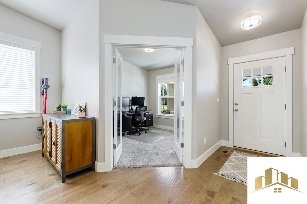 a living room with a white door and a home office