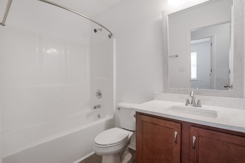A white bathroom with a toilet, sink, and bathtub.