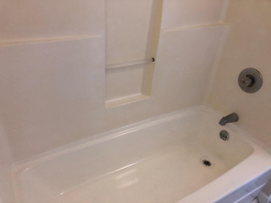 a white bathroom with a shower and a sink