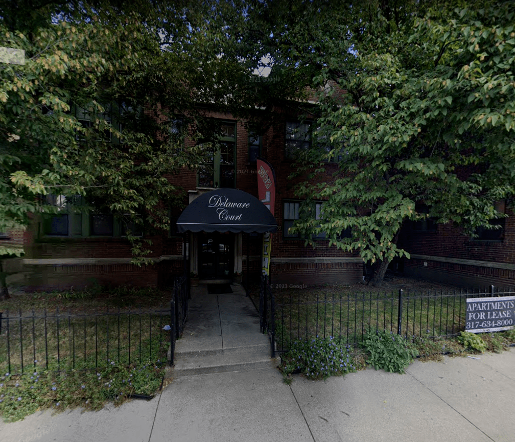 a building with a black awning in front of a sidewalk