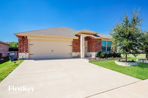A house with a garage and a driveway in front of it.