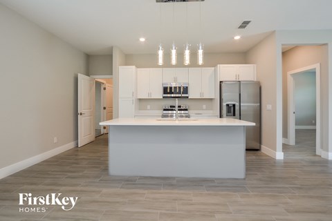 A modern kitchen with a large island and stainless steel appliances.