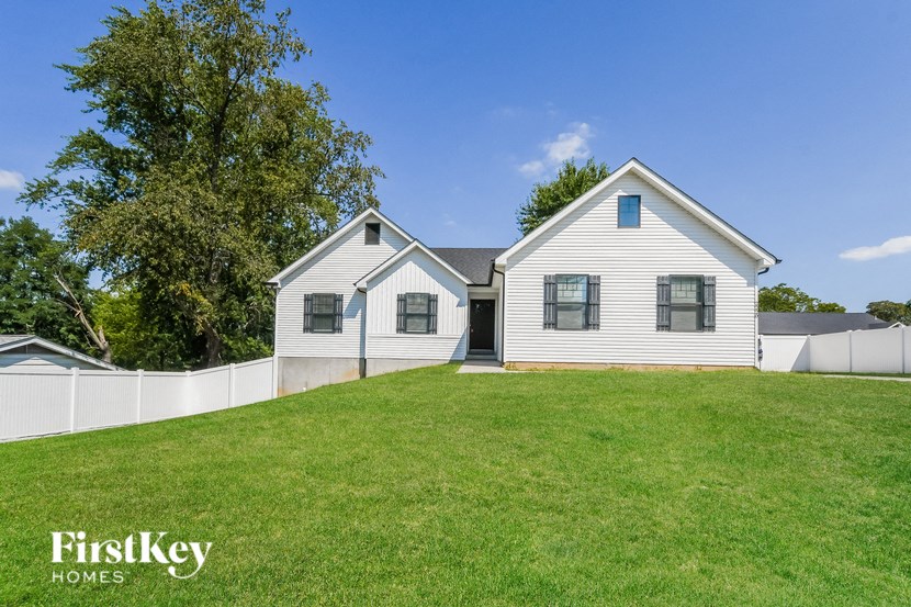 a white house with a yard and a white fence