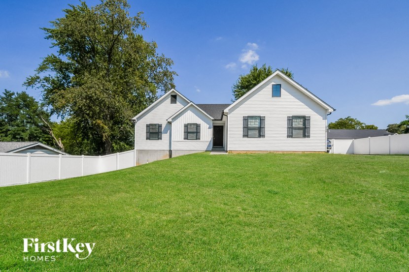 a white house with a yard and a white fence