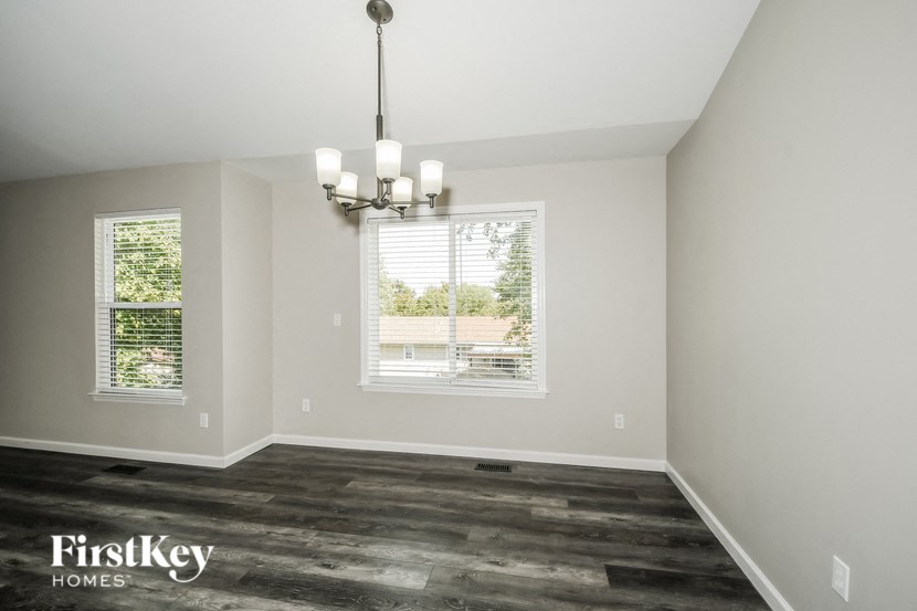 the living room of a home with wood floors and a chandelier