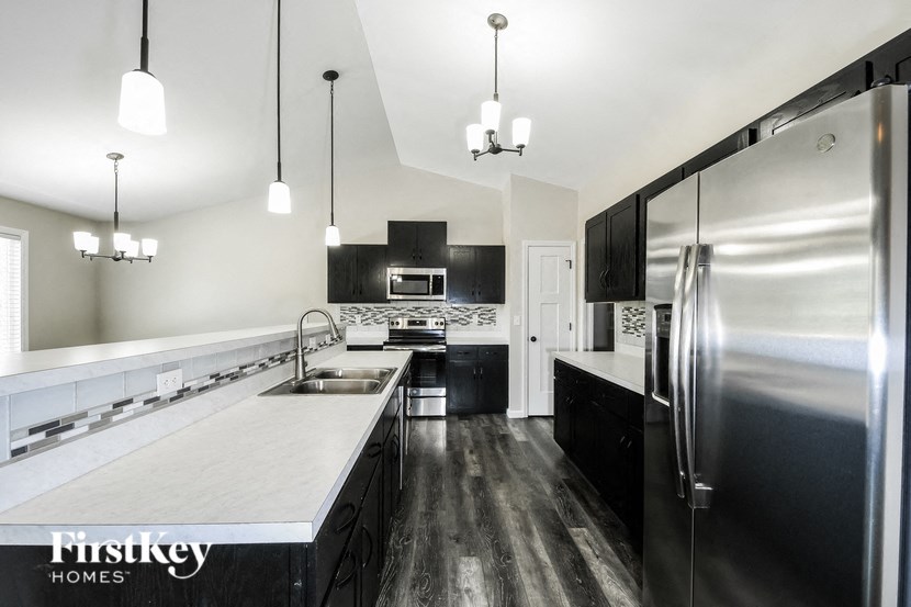 a large kitchen with stainless steel appliances and white countertops