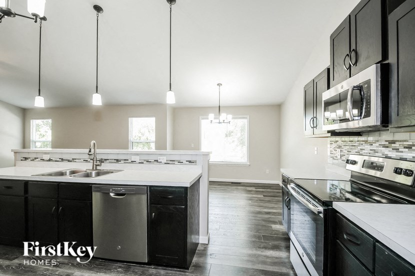 a kitchen with black and white counters and stainless steel appliances