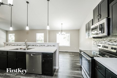 a kitchen with black and white counters and stainless steel appliances