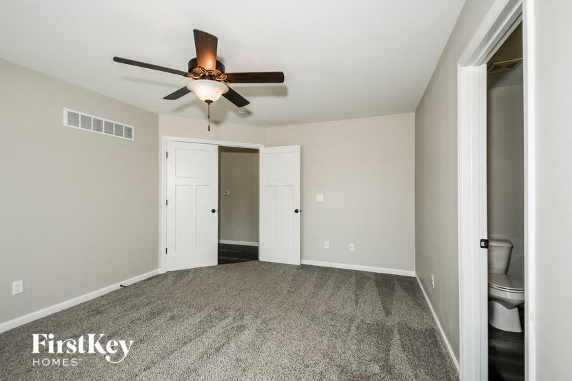 an empty room with a ceiling fan and a closet