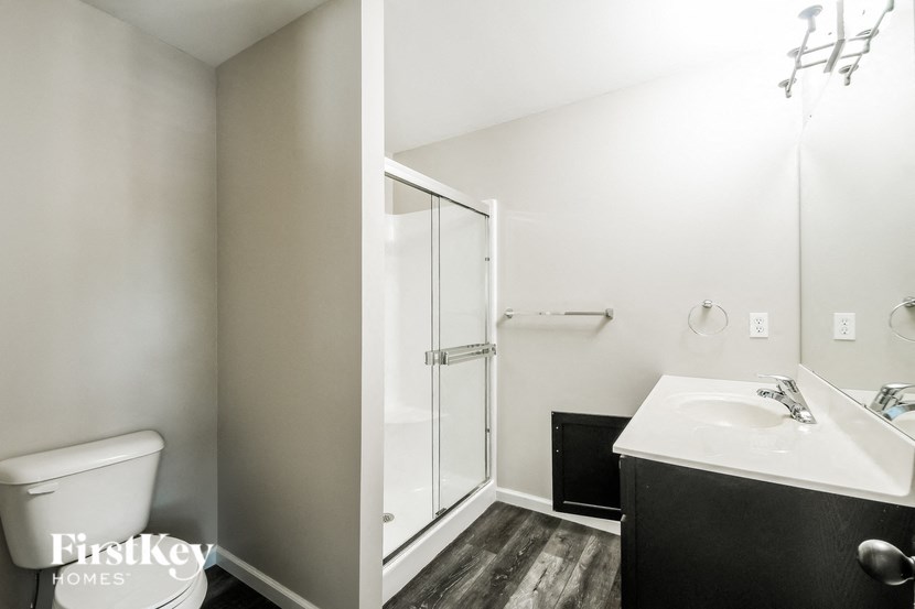 a bathroom with a shower and a sink and a toilet