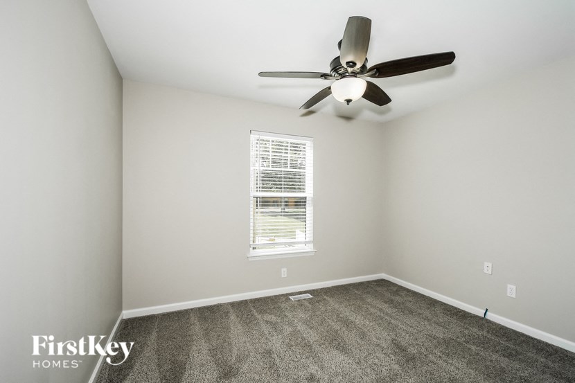 a bedroom with carpet and a ceiling fan