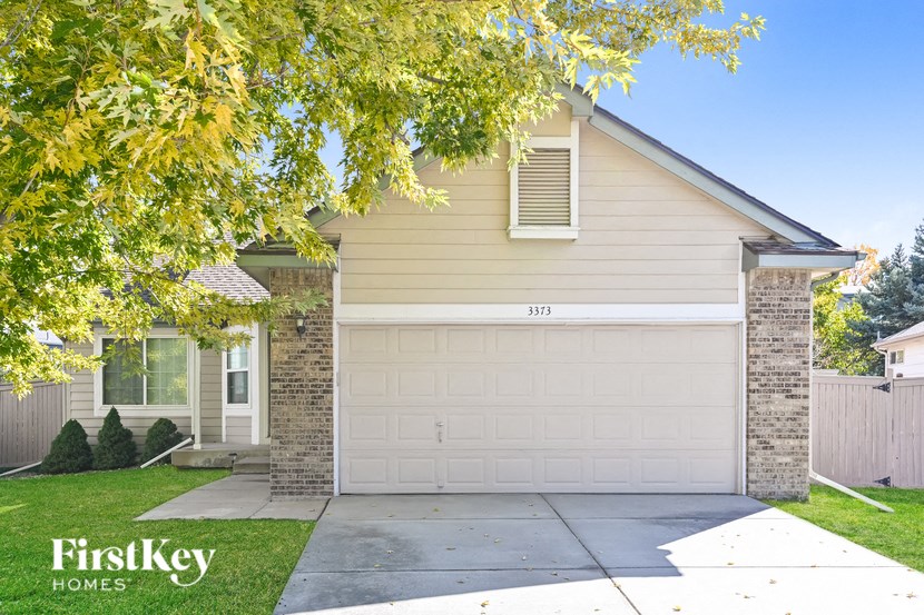 A house with a garage door numbered 3373 is for sale.