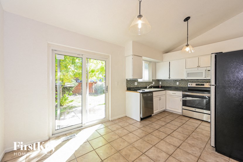 A kitchen with black appliances and white cabinets.