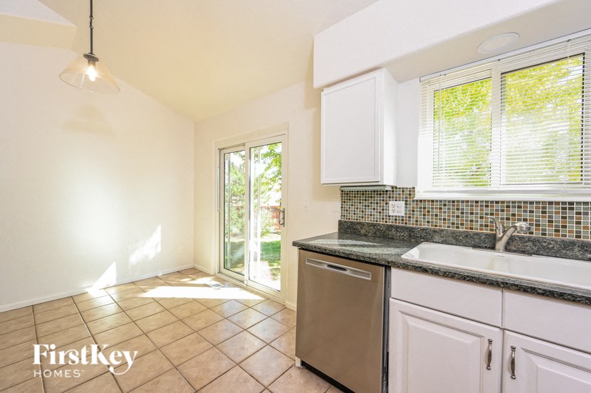 A kitchen with white cabinets and a tiled floor.