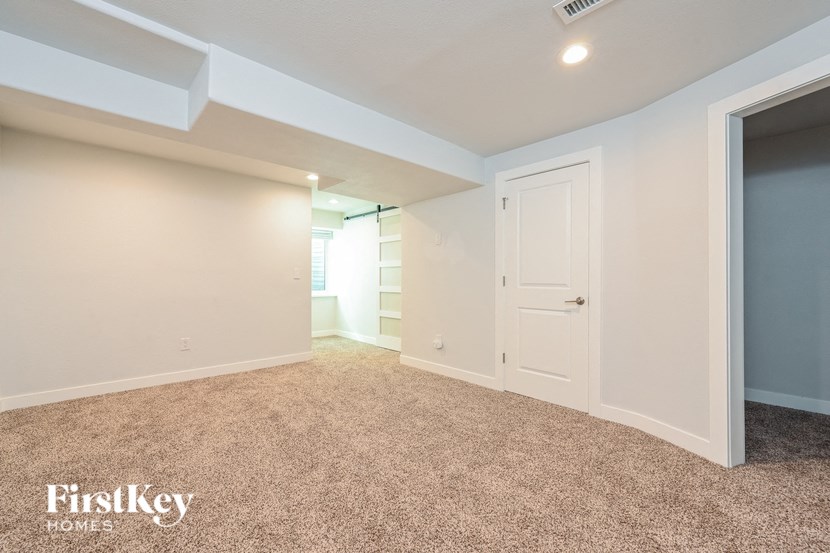 A room with a carpeted floor and a door on the right side.