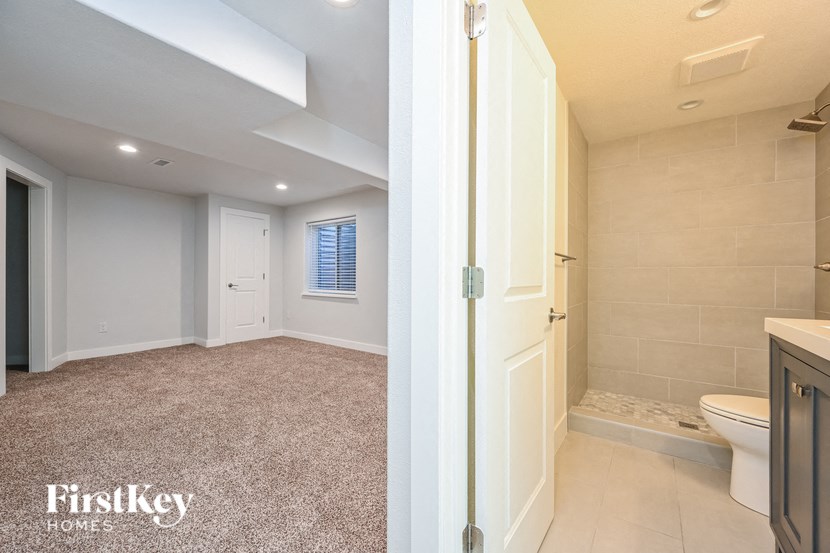 A bathroom with a toilet, sink, and shower area.