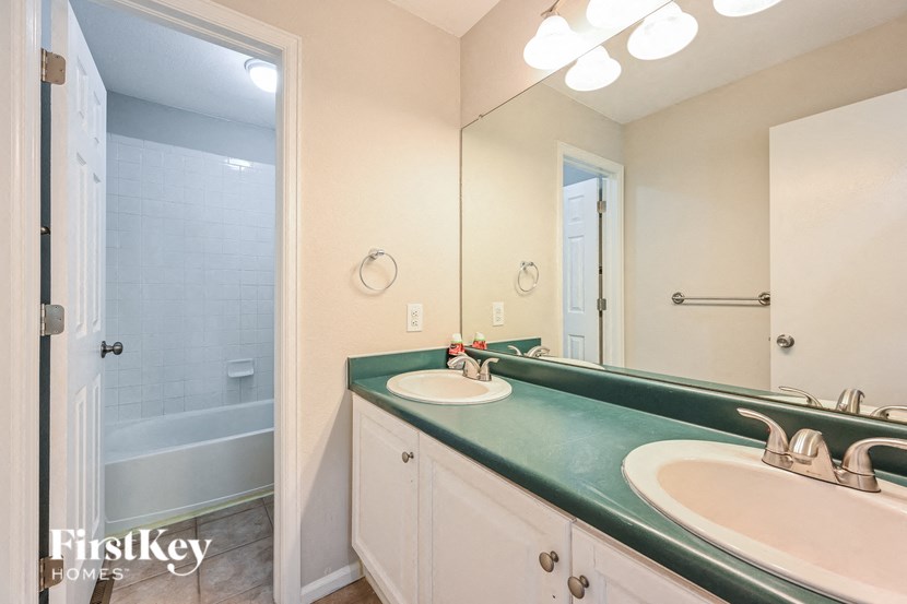A bathroom with a green counter top and a white sink.