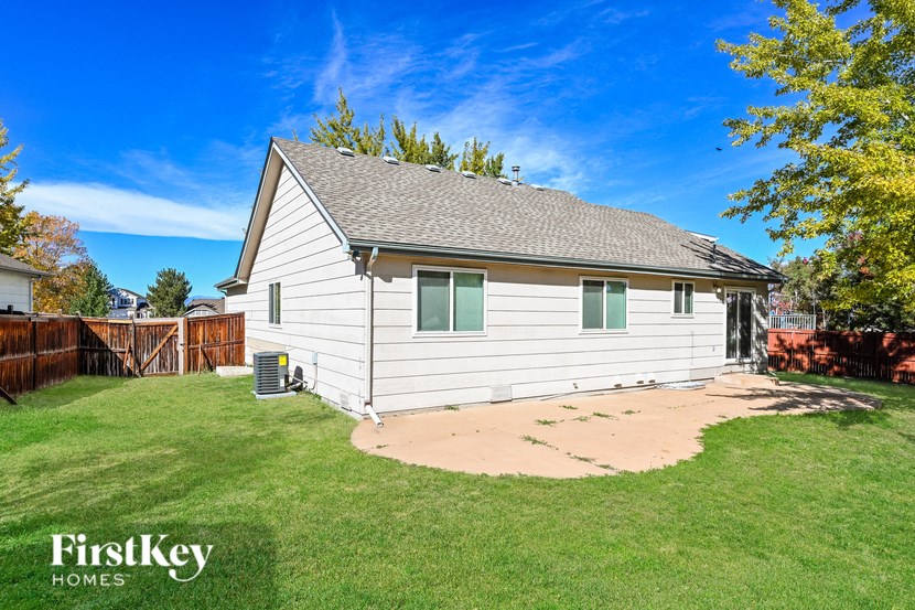A house with a brown roof and a green lawn.