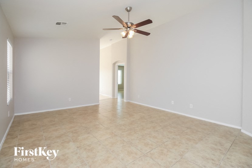 a empty living room with a ceiling fan