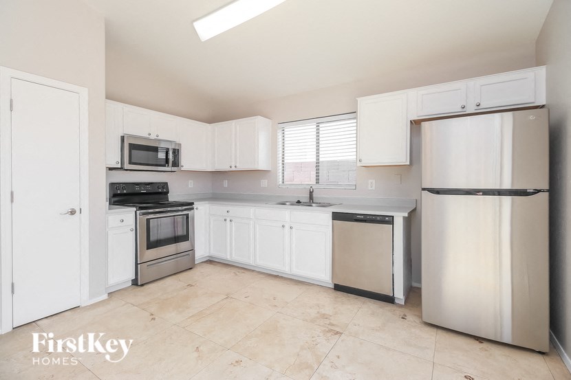 a white kitchen with stainless steel appliances and white cabinets