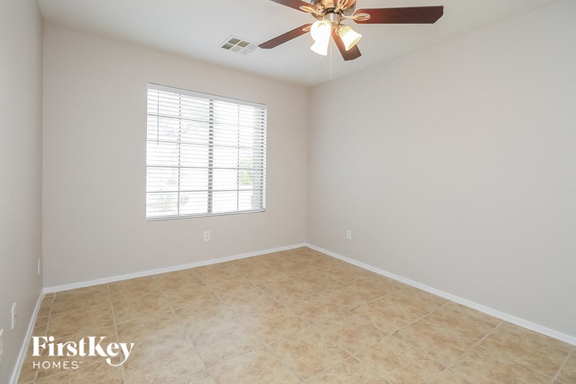 a empty room with a ceiling fan and a window