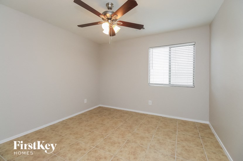 a bedroom with a ceiling fan and a tiled floor
