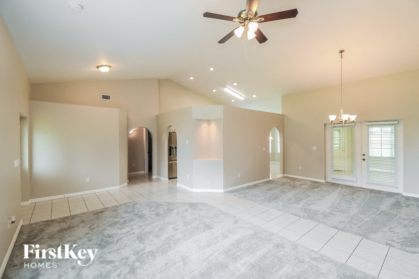 an empty living room with a ceiling fan