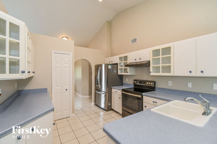 a kitchen with white cabinets and stainless steel appliances