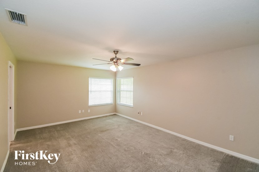 a bedroom with carpet and a ceiling fan
