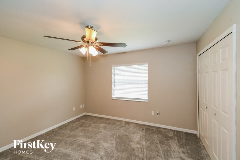 a bedroom with a ceiling fan and a closet