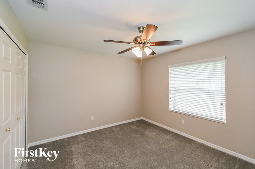 a bedroom with a ceiling fan and a window