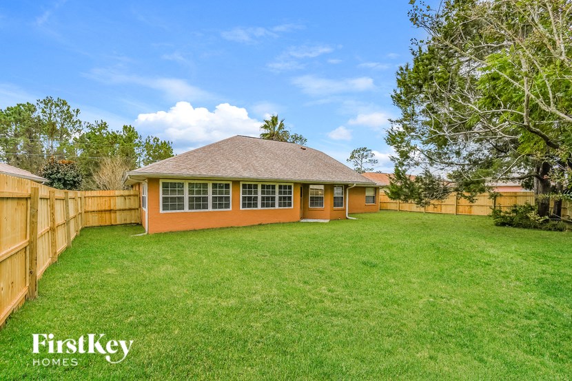 a backyard with a fence and a house