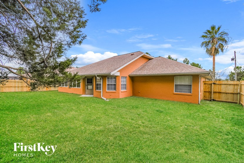a backyard with a house and a grass lawn