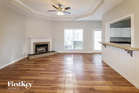 A spacious living room with a fireplace and wooden flooring.