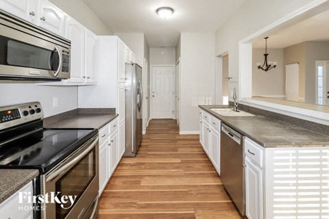 A kitchen with white cabinets and stainless steel appliances.