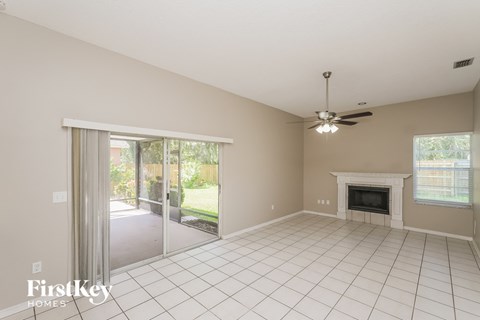 A spacious living room with a fireplace and sliding glass doors.