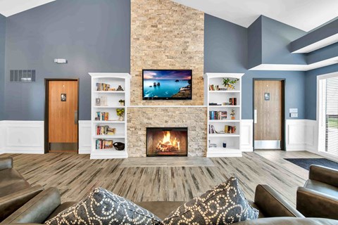 A living room with a fireplace and a television on the wall.