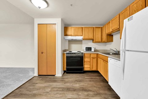 A kitchen with wooden cabinets and a white refrigerator.