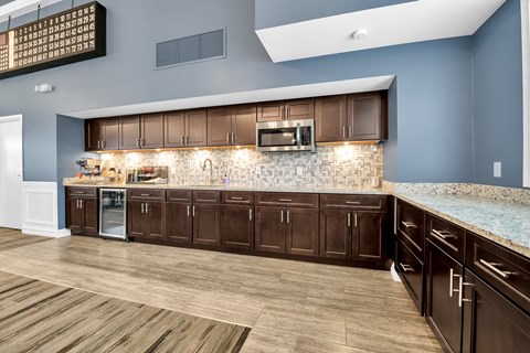 A kitchen with brown cabinets and a stone backsplash.