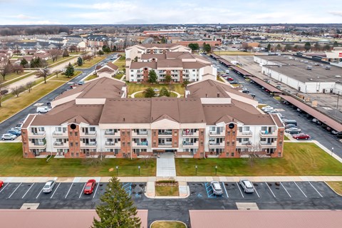A large apartment complex with a parking lot in front.