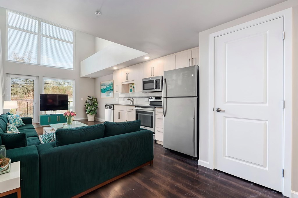 A kitchen with a refrigerator, microwave, and oven.